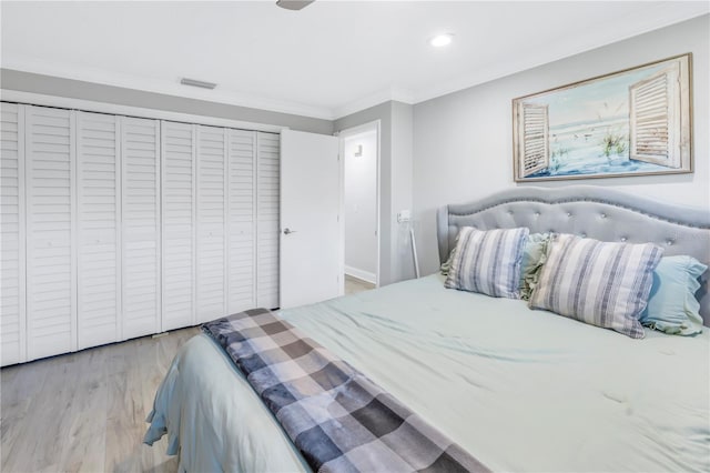 bedroom with a closet, ornamental molding, and light hardwood / wood-style flooring