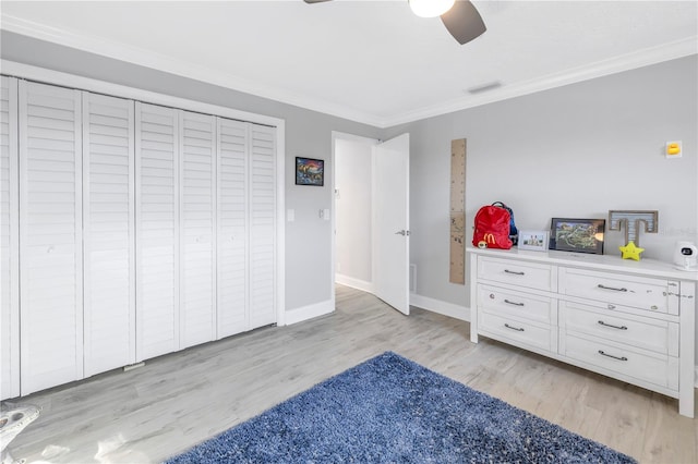 bedroom with ornamental molding, light hardwood / wood-style flooring, ceiling fan, and a closet