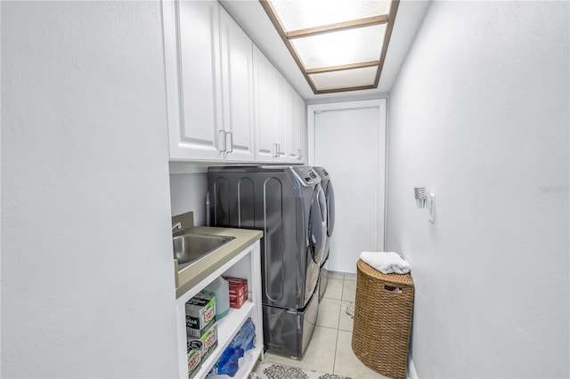 laundry room featuring washer and dryer, cabinets, light tile patterned floors, and sink