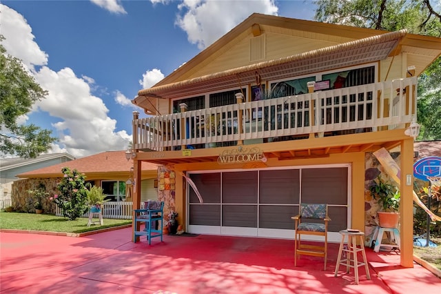 rear view of property featuring a garage and a balcony