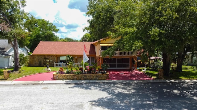 view of front of property featuring a porch, a garage, and a front lawn