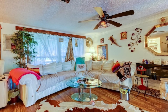 living room with a textured ceiling, ceiling fan, ornamental molding, and hardwood / wood-style flooring