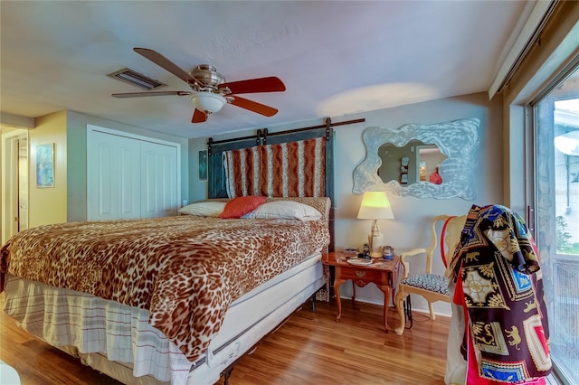 bedroom featuring multiple windows, ceiling fan, and wood-type flooring