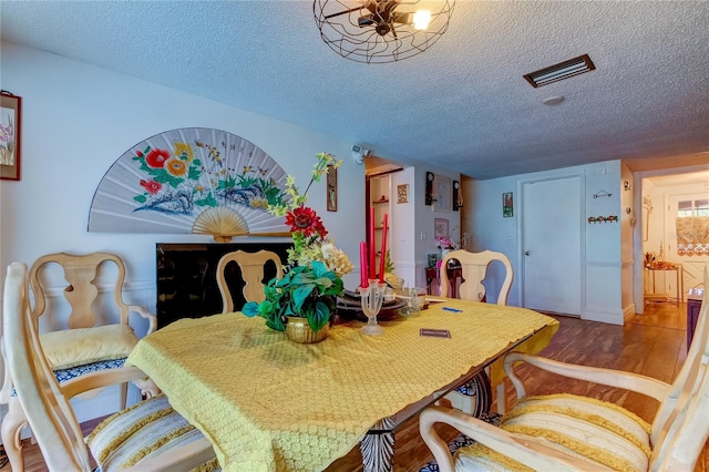 dining room with a textured ceiling and hardwood / wood-style flooring