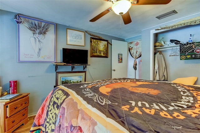 bedroom featuring wood-type flooring, ceiling fan, and a closet