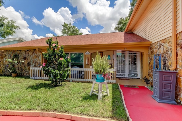 rear view of house with covered porch and a lawn