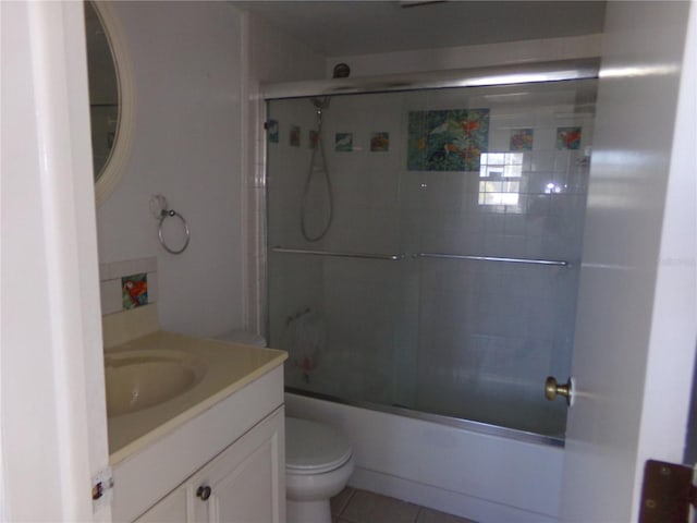 full bathroom featuring combined bath / shower with glass door, vanity, toilet, and tile patterned floors