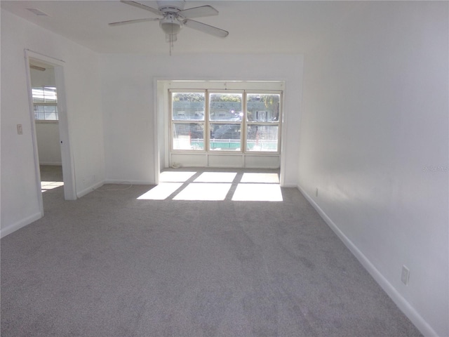 carpeted spare room featuring ceiling fan