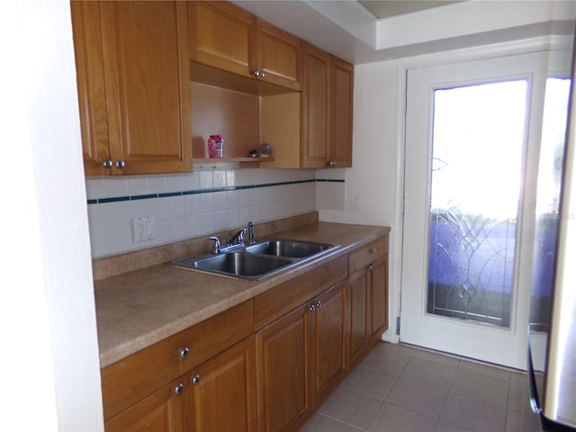 kitchen featuring tile patterned flooring, sink, and backsplash