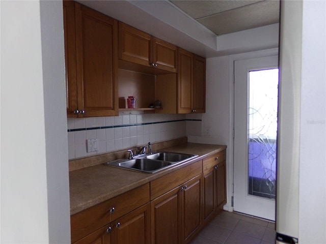 kitchen with sink, decorative backsplash, and tile patterned flooring