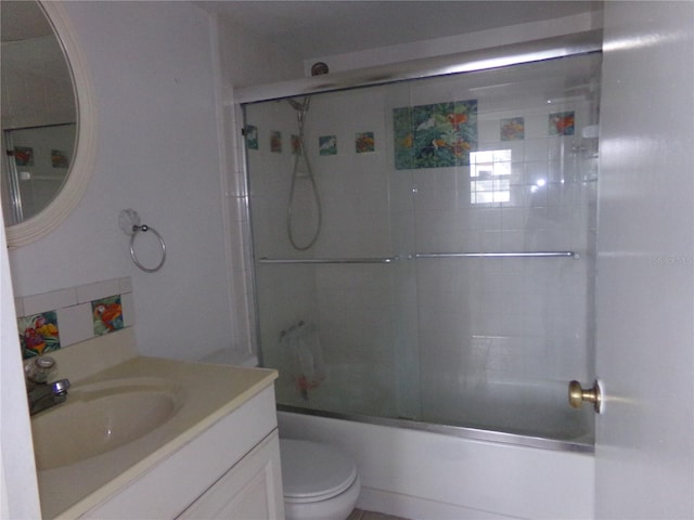 full bathroom with shower / bath combination with glass door, vanity, and toilet