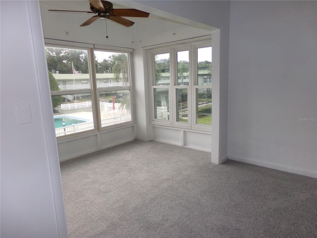 carpeted spare room featuring ceiling fan