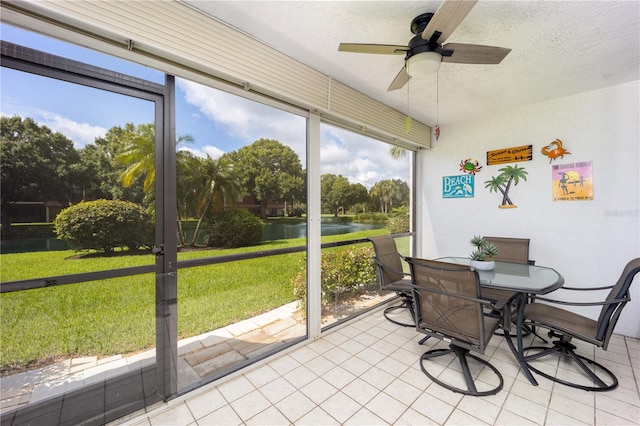 sunroom / solarium featuring a water view, ceiling fan, and a wealth of natural light