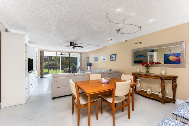 dining area featuring ceiling fan, expansive windows, and a textured ceiling