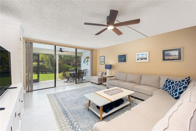 tiled living room featuring ceiling fan, expansive windows, and a textured ceiling