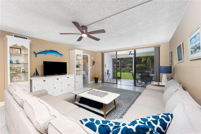 living room with a textured ceiling, light tile patterned flooring, and ceiling fan