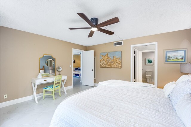 bedroom featuring a textured ceiling, connected bathroom, and ceiling fan