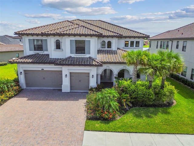 mediterranean / spanish-style house with a garage and a front yard