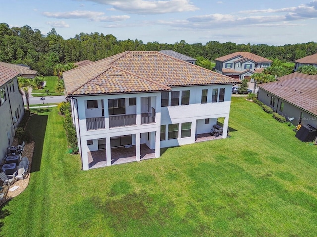 back of house with a balcony and a yard