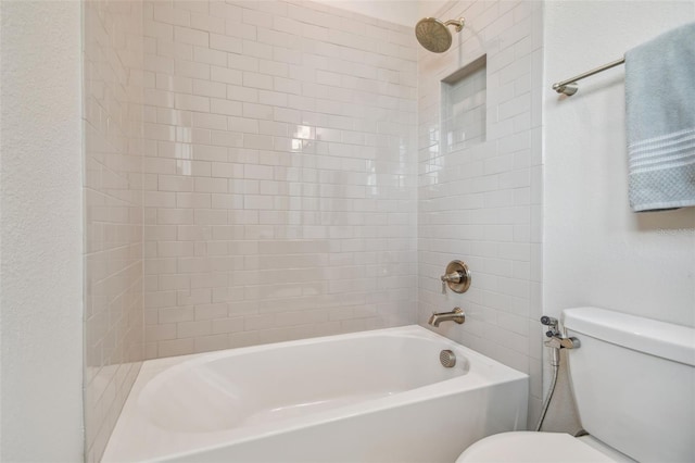 bathroom with tiled shower / bath and toilet