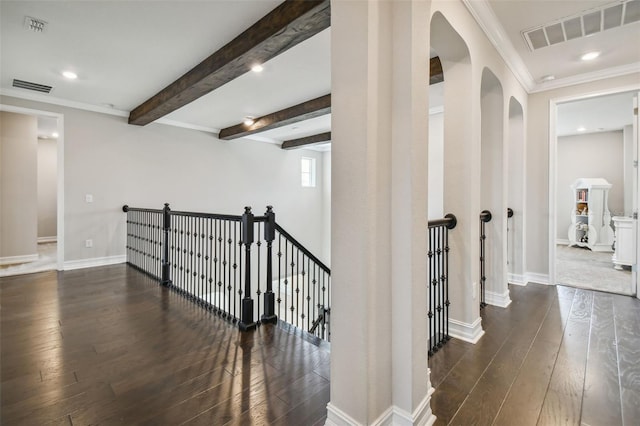 hallway with ornamental molding, dark hardwood / wood-style flooring, and beam ceiling