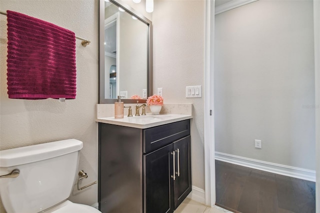 bathroom with vanity, toilet, and wood-type flooring