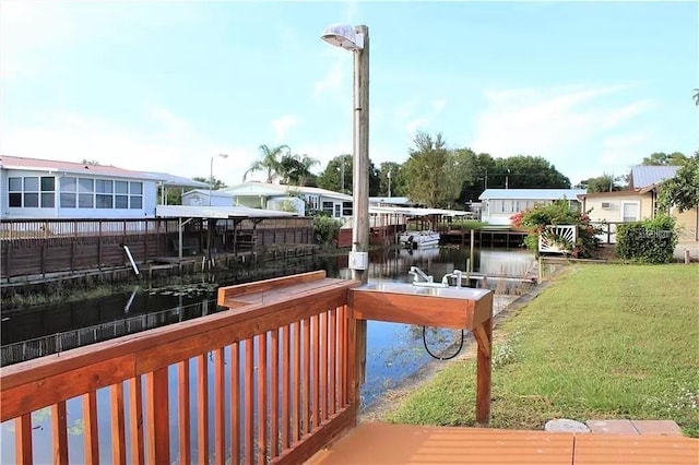 wooden deck featuring a water view and a yard