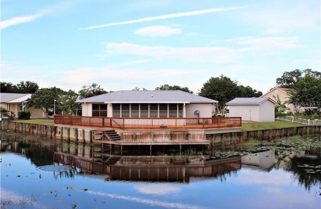 rear view of property featuring a deck with water view