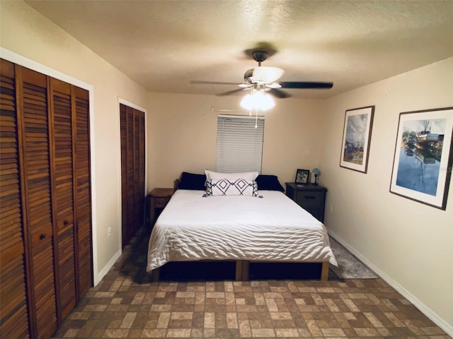 bedroom featuring ceiling fan and multiple closets