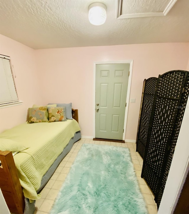 bedroom with a textured ceiling and light tile patterned flooring