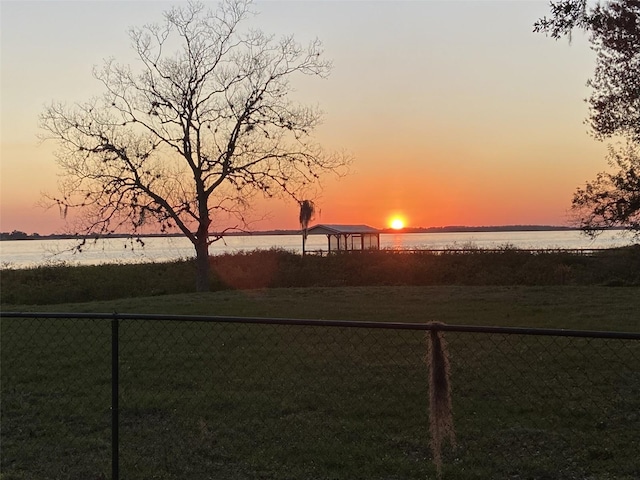 yard at dusk featuring a gazebo and a water view