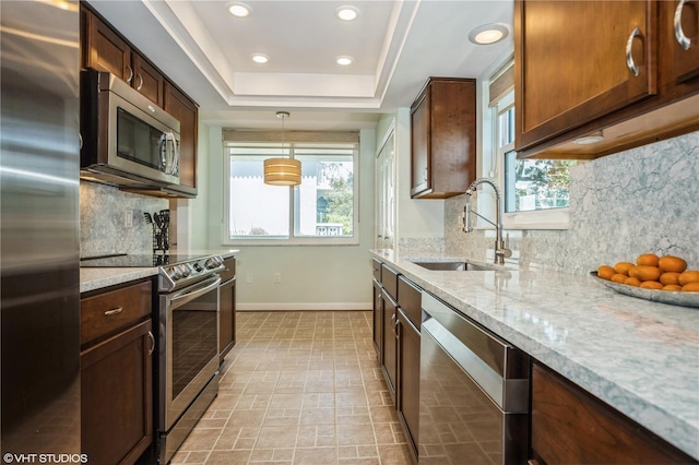 2630 Pearce Dr Unit 404, Clearwater, FL 33764 - kitchen featuring baseboards, a tray ceiling, light stone counters, appliances with stainless steel finishes, and a sink