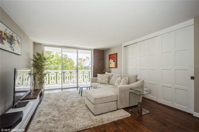 living room featuring dark wood-type flooring and floor to ceiling windows