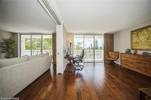 home office with floor to ceiling windows and dark hardwood / wood-style floors