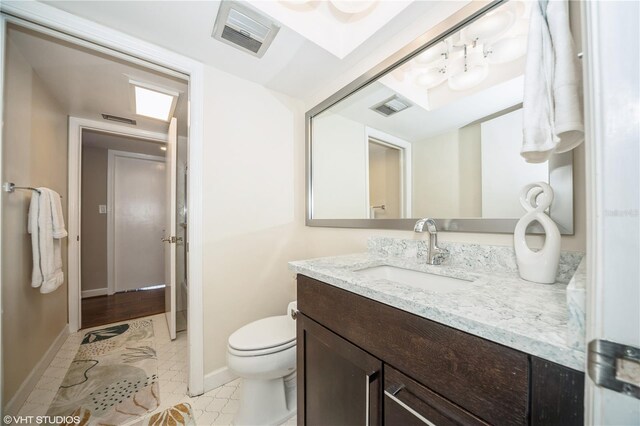 bathroom featuring tile patterned flooring, vanity, and toilet