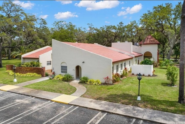 2630 Pearce Dr Unit 404, Clearwater, FL 33764 - mediterranean / spanish house with stucco siding, a tile roof, and a front lawn
