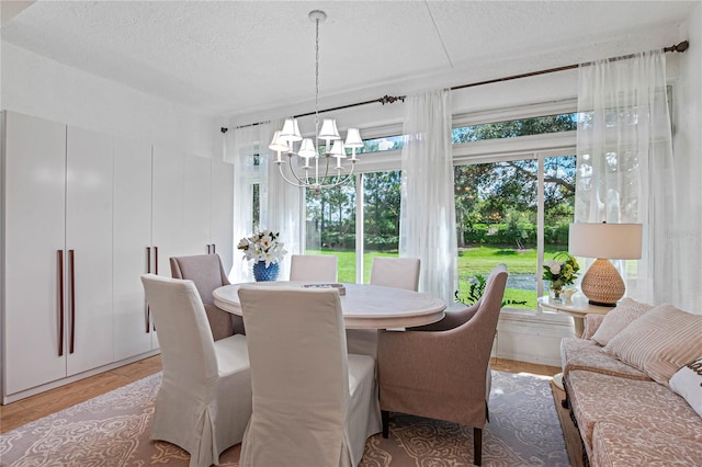 dining space with a textured ceiling and a notable chandelier