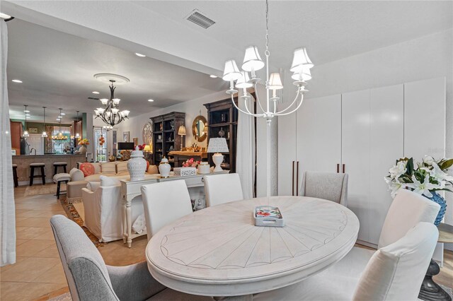 dining room with light tile patterned floors and a notable chandelier