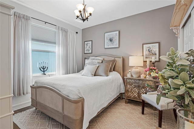 bedroom with an inviting chandelier and light hardwood / wood-style flooring