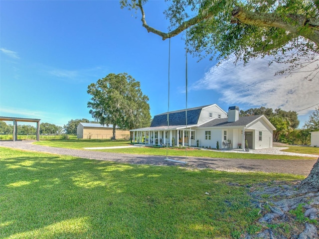 rear view of property with a yard, covered porch, and a garage