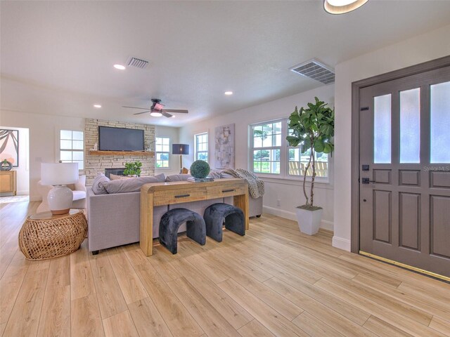 living room featuring light wood finished floors, visible vents, and recessed lighting