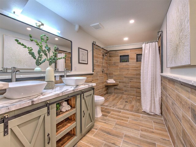 bathroom with vanity, toilet, a shower with curtain, and a textured ceiling