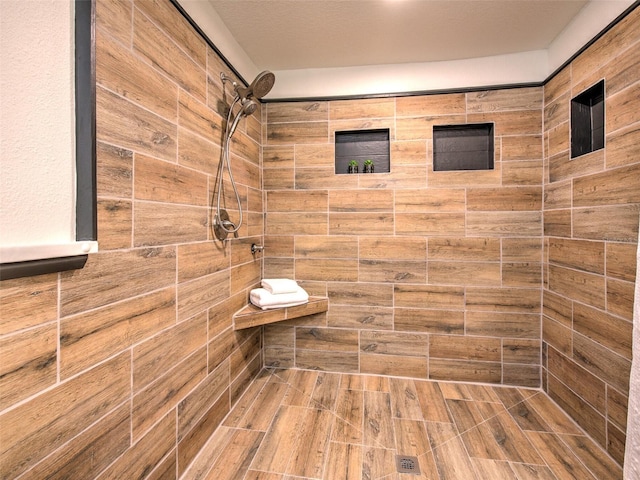 bathroom with tiled shower and hardwood / wood-style floors