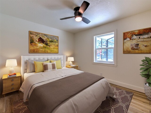 bedroom with baseboards, wood finished floors, ceiling fan, and a textured ceiling