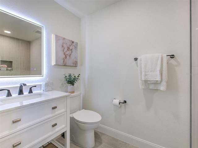 bathroom with vanity, toilet, and tile patterned floors