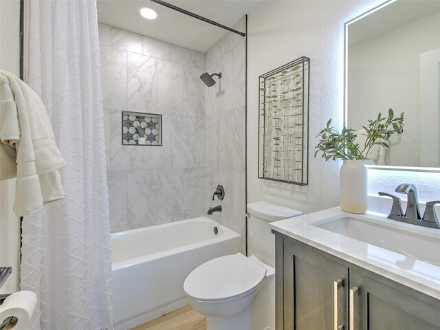 full bathroom featuring wood finished floors, toilet, shower / tub combo with curtain, and vanity