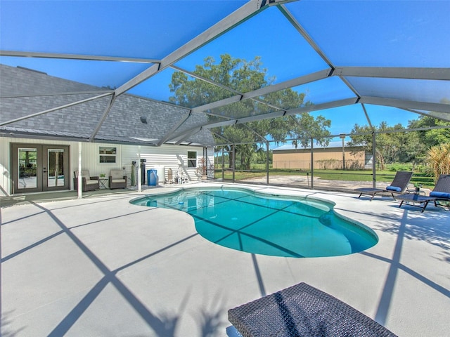 view of pool with glass enclosure, a patio, and french doors