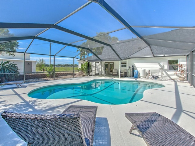 view of swimming pool featuring glass enclosure and a patio area