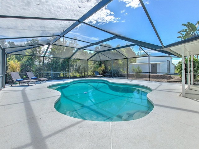 view of pool featuring glass enclosure and a patio area