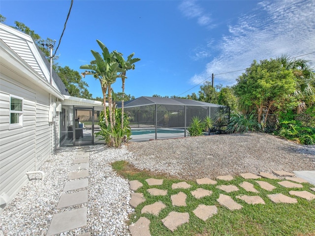 view of yard featuring a patio area and glass enclosure